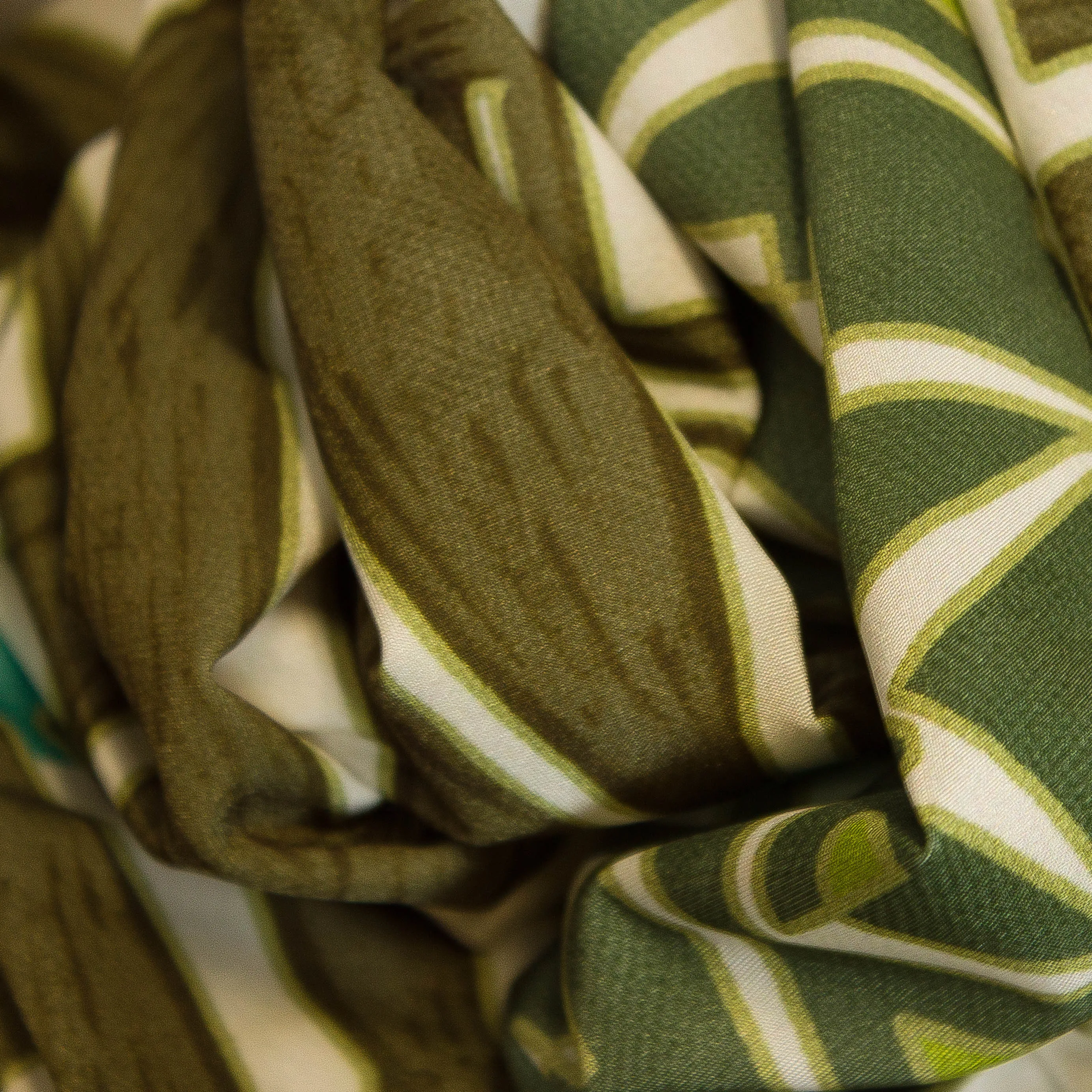 Polyester wit met abstracte figuren in groen en turquoise